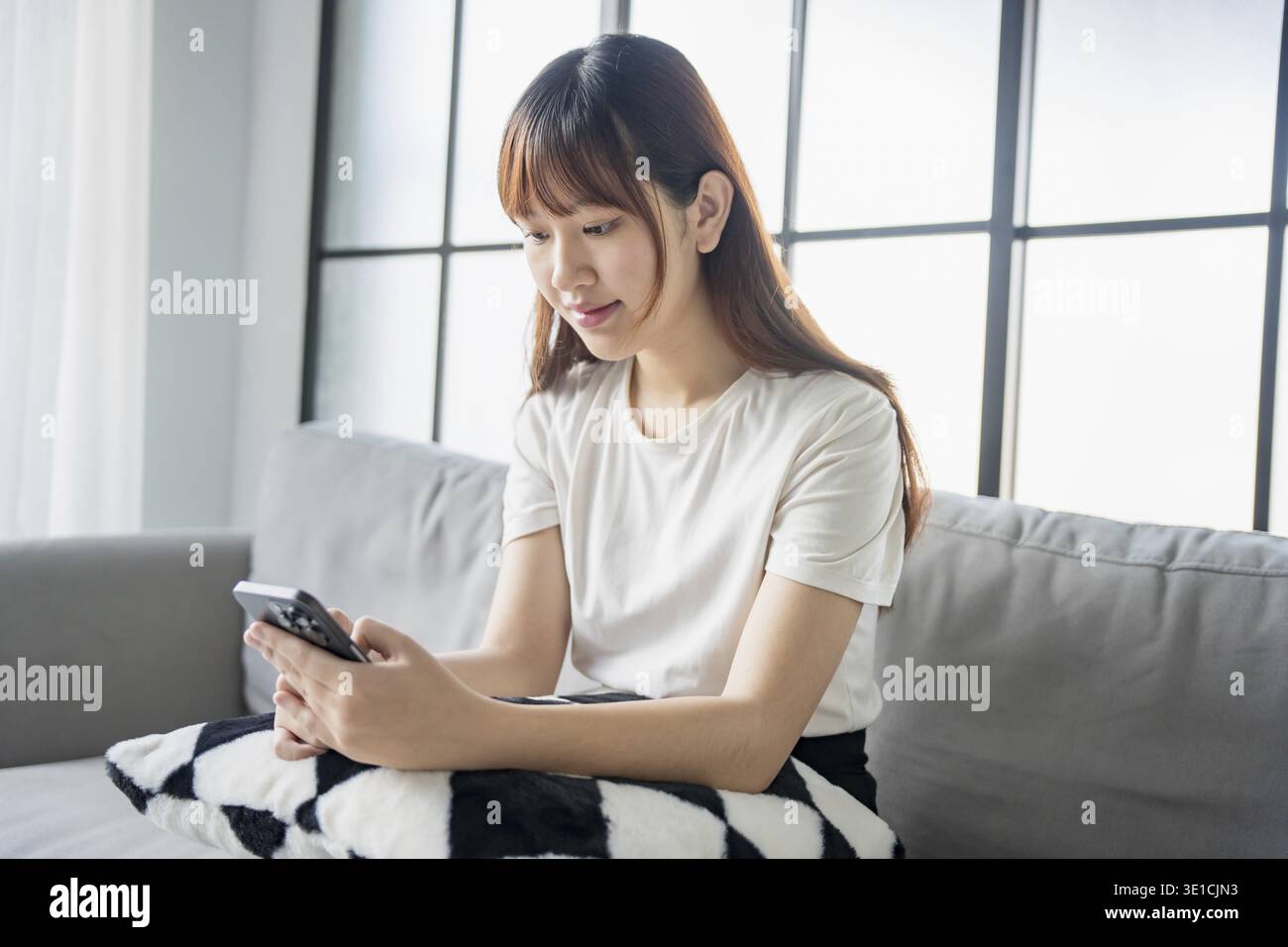 Donna asiatica che utilizza le informazioni di navigazione dei messaggi di testo sullo smartphone Foto Stock