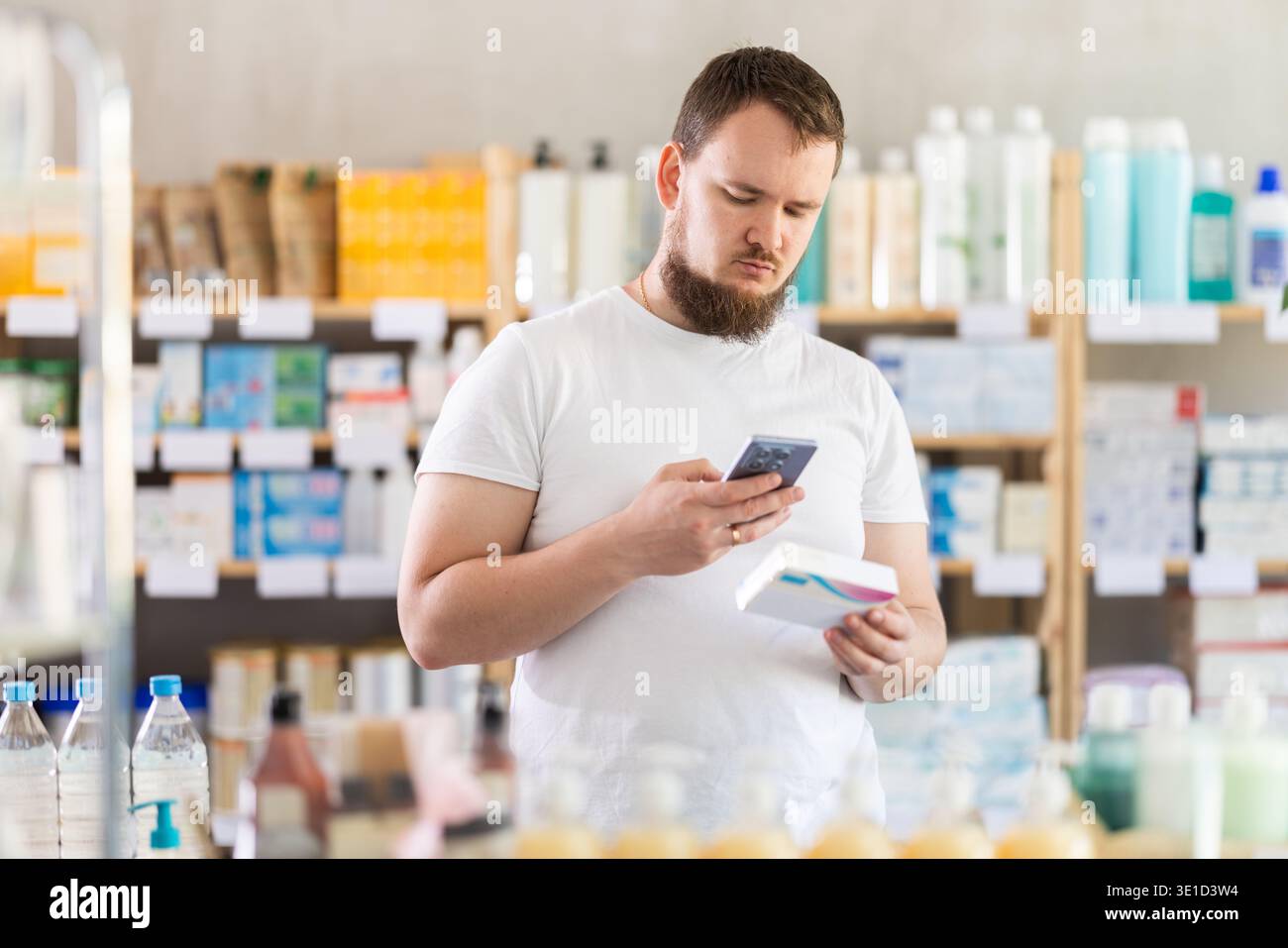 Man scansiona il codice sulla confezione di pillole per controllare la data di scadenza Foto Stock