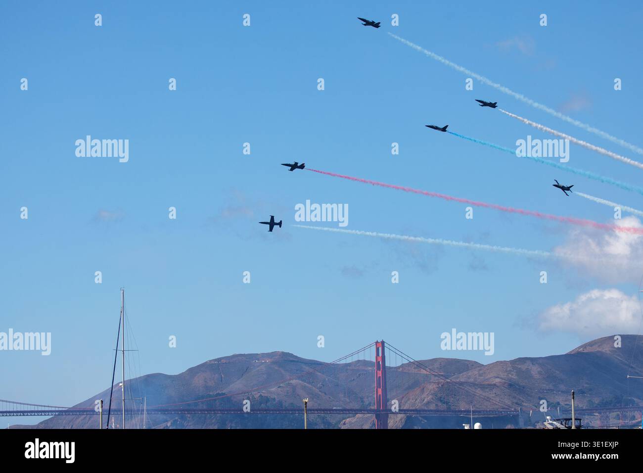 Una formazione di sei L-39 Albatros del Breitling Jet Team vola in formazione sopra il Golden Gate Bridge, lasciando tracce di rosso, bianco e blu Foto Stock