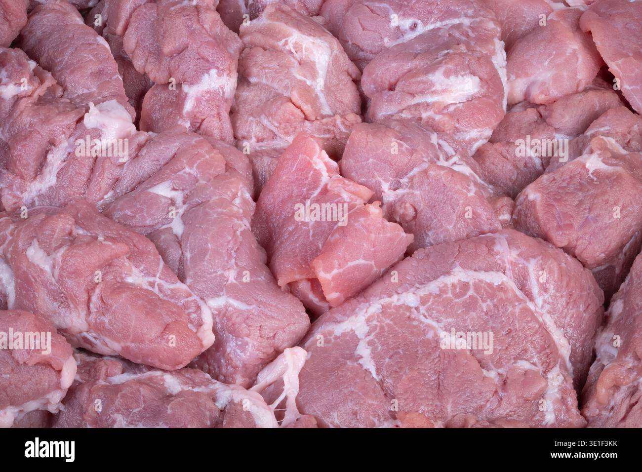 Superficie di maiale crudo con linee di grasso intricate. Vista ravvicinata della carne di maiale cruda che mette in risalto le delicate vene grasse e la dettagliata struttura muscolare Foto Stock