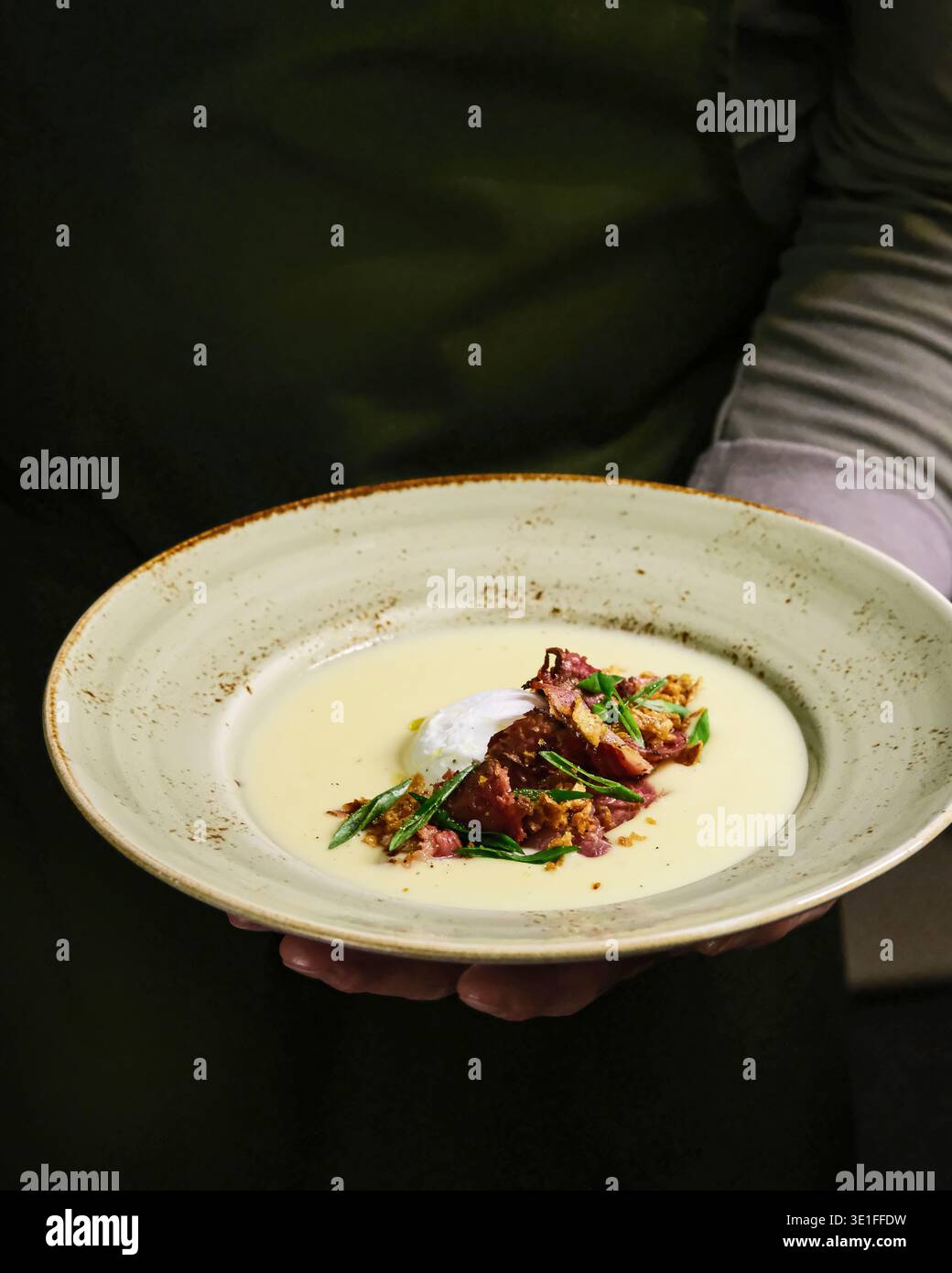 Mostra minestre gourmet. Vetrina culinaria con brodo di manzo setoso ricoperto di tuorlo in camicia e Microgreens Foto Stock