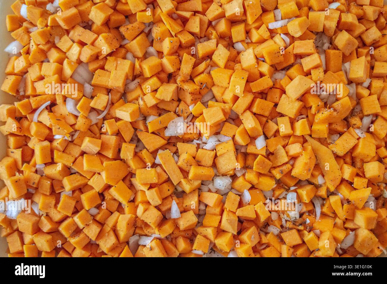 Cubetti di zucca e cipolla in spezie. consistenza della zucca a dadini con cipolle e spezie per riempire la torta di zucca. Foto di alta qualità Foto Stock