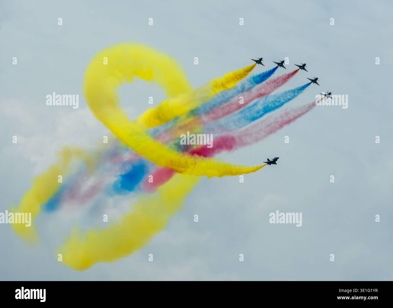 Vista aerea degli aerei che si innalzano nel cielo, dipingendo vivaci sentieri di fumo giallo, rosso e blu, Changi Exhibition Centre, Singapore. Foto Stock