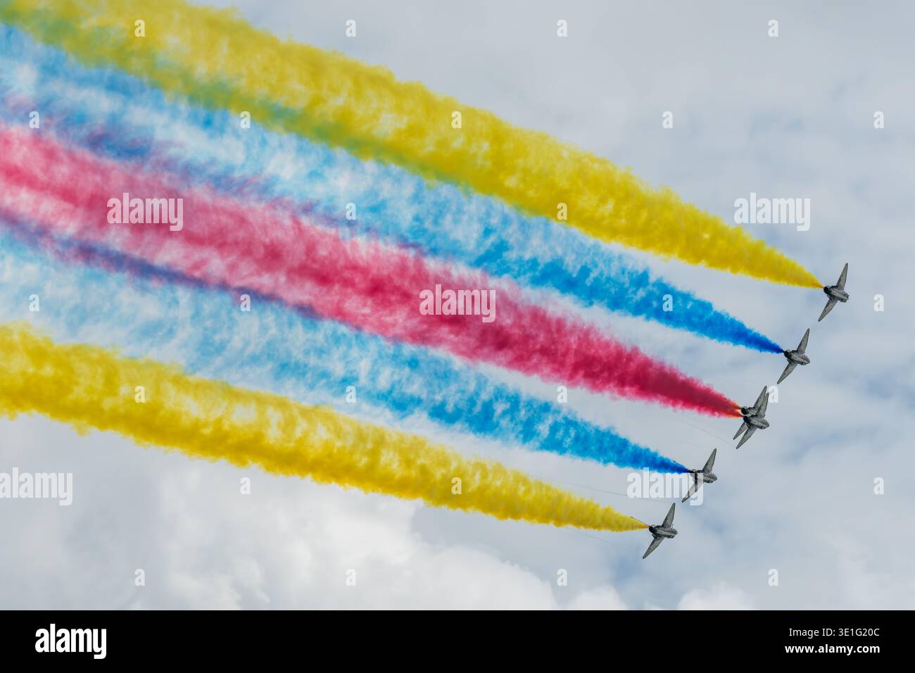 Vista aerea di vivaci sentieri di fumo colorati che dipingono il cielo sopra il centro espositivo Changi con aeroplani che si innalzano graziosamente, Changi, Singapore. Foto Stock