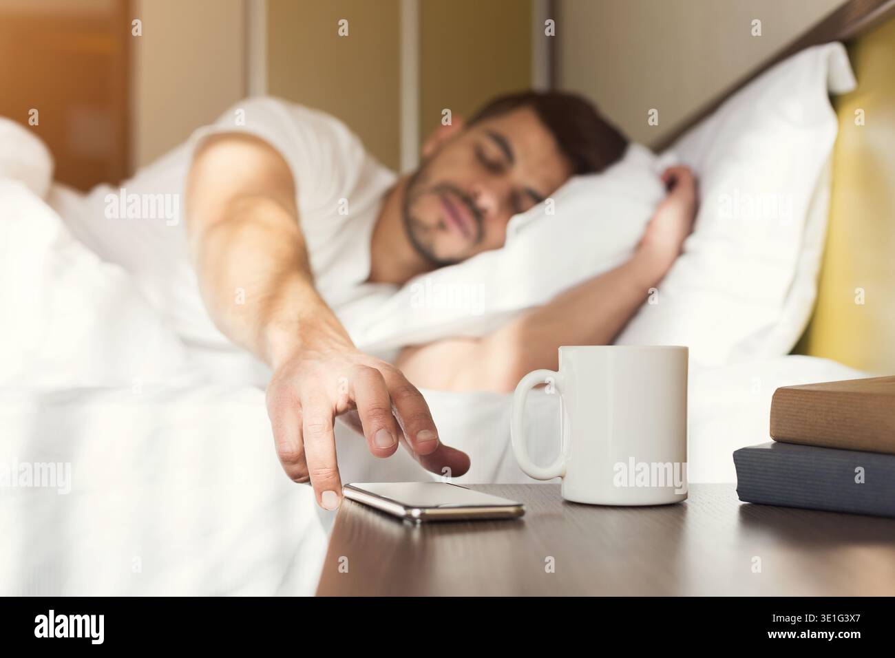 Un ragazzo assonnato che si sveglia presto dopo il segnale della sveglia Foto Stock