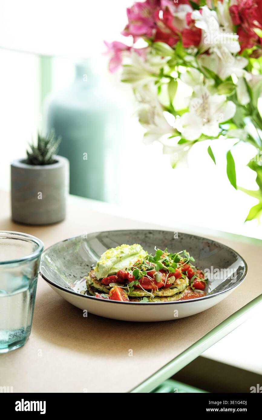 Piatto di pomodoro avocado fresco. Brunch mattutino con avocado cremoso e pomodori ciliegini su davanzale Foto Stock