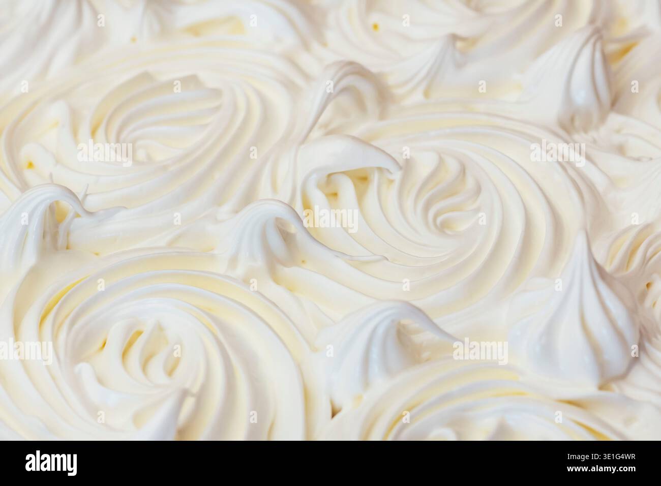 Uno sfondo full-frame ad angolo elevato che mostra la delicata superficie incrinata di una crosta di meringa bianca appena sfornata. Foto Stock
