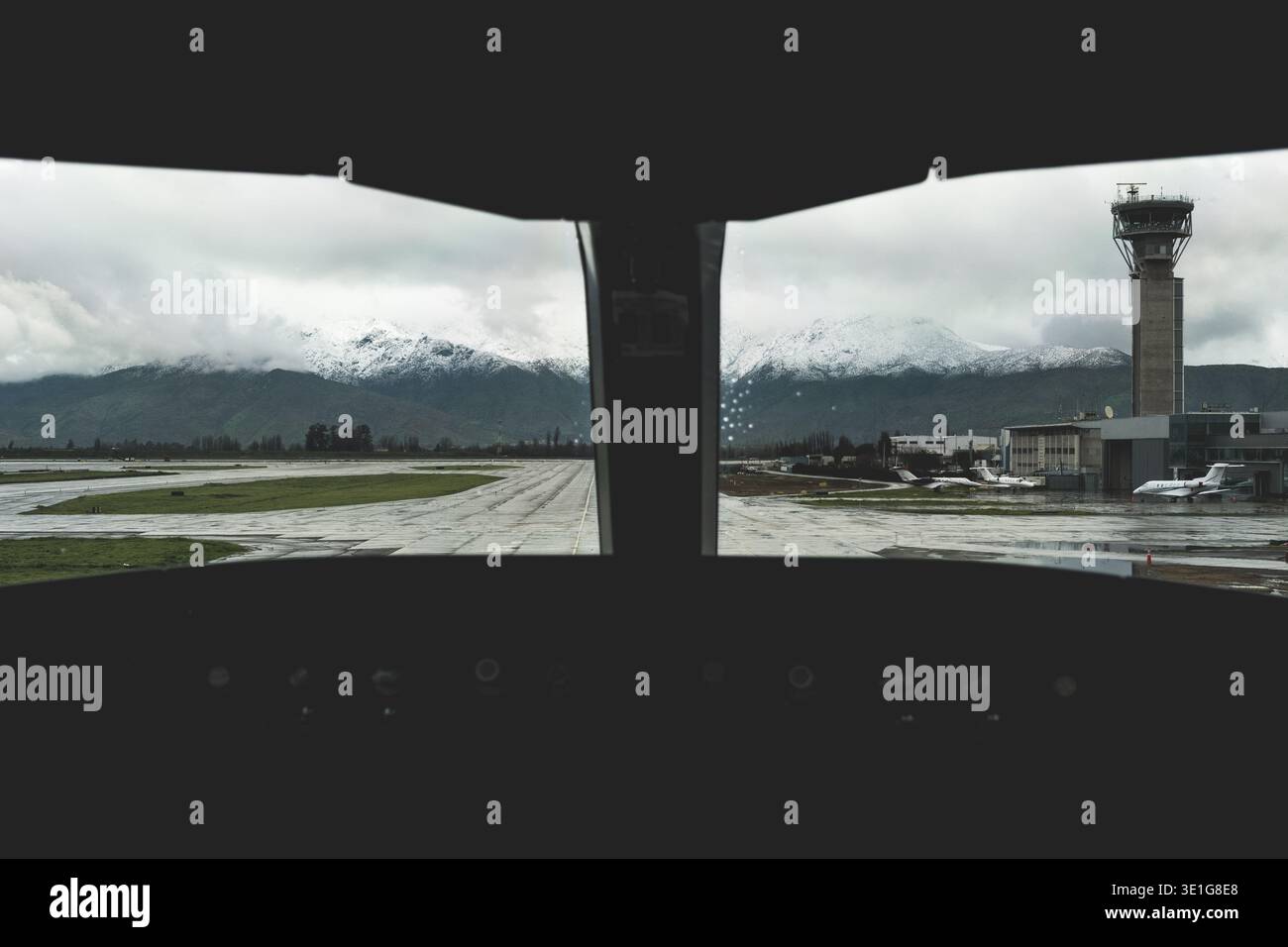 Vista dell'aeroporto dalla cabina di pilotaggio degli aerei con montagne innevate Foto Stock