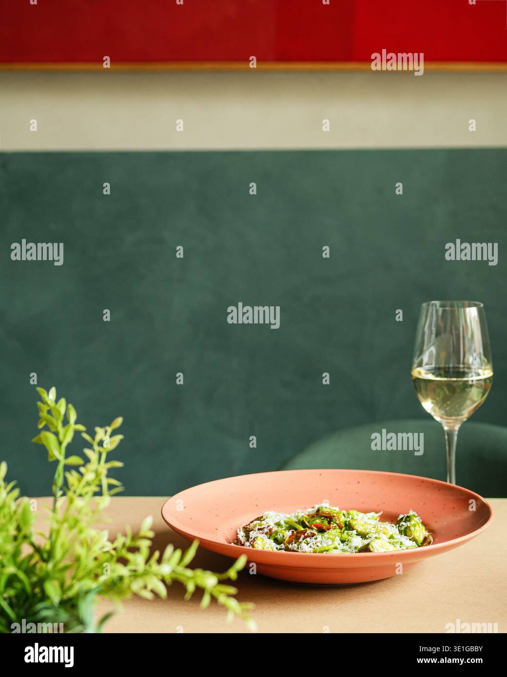 Elegante pasto all'aperto con un'atmosfera verde. Sofisticato scenario gastronomico a mezzogiorno con vino e piante Foto Stock