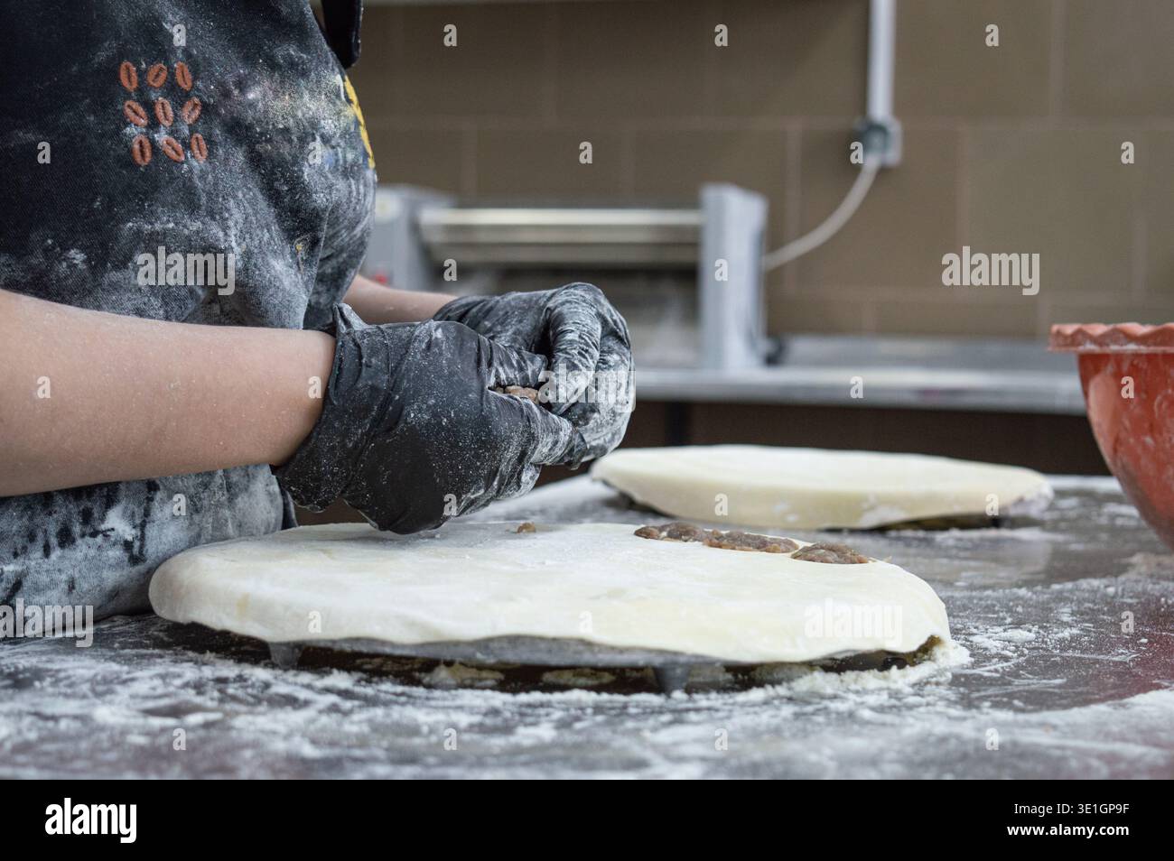 Ragazze al lavoro nella produzione di gnocchi. le mani con i guanti preparano gnocchi di carne. senza volti e persone. Foto di alta qualità Foto Stock