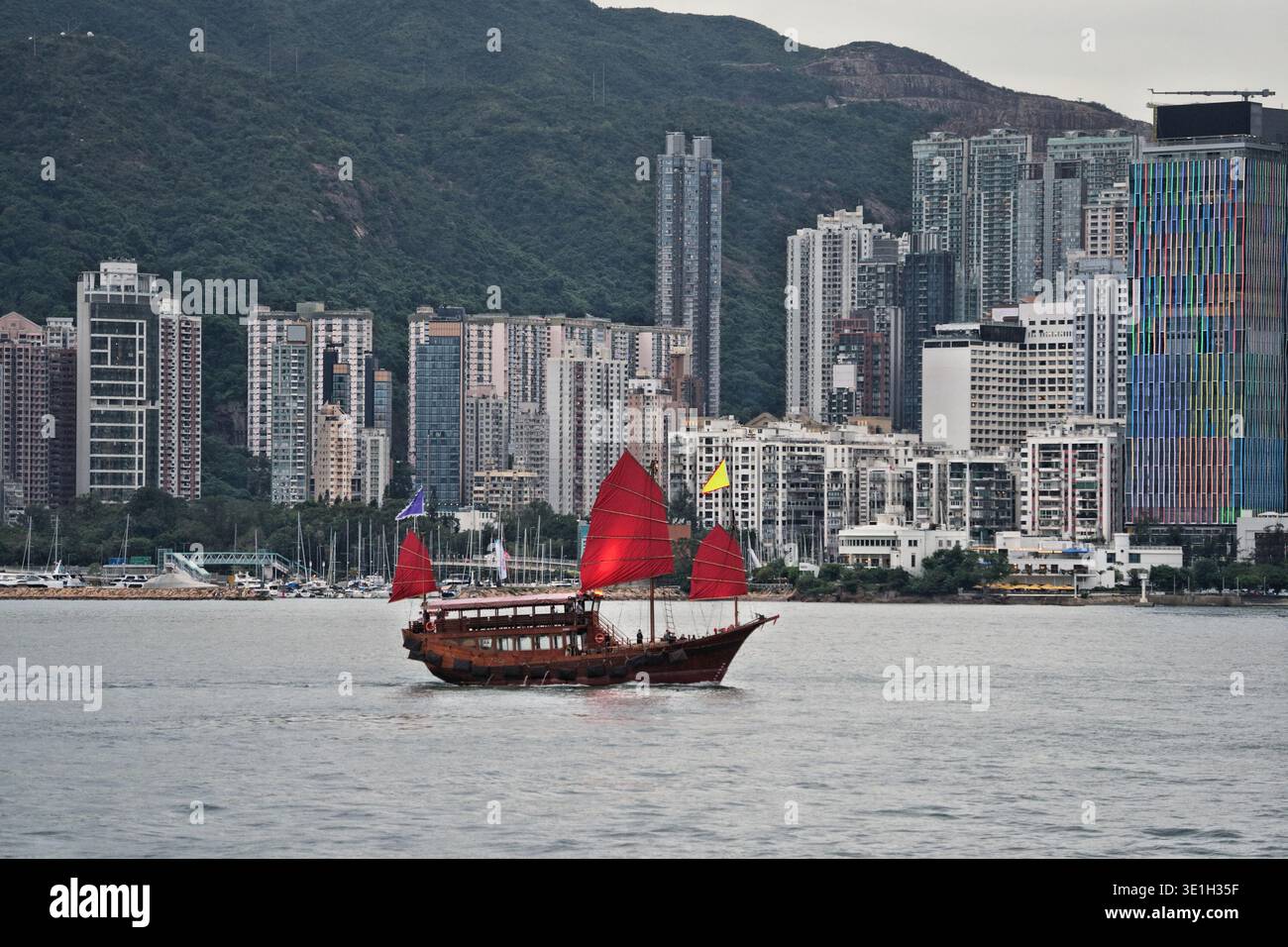 Paesaggio urbano di Hong Kong con junk boat sul Victoria Harbour. Vista dello skyline della grande città dal lungomare di Kowloon Tsim Sha Tsui. Foto Stock
