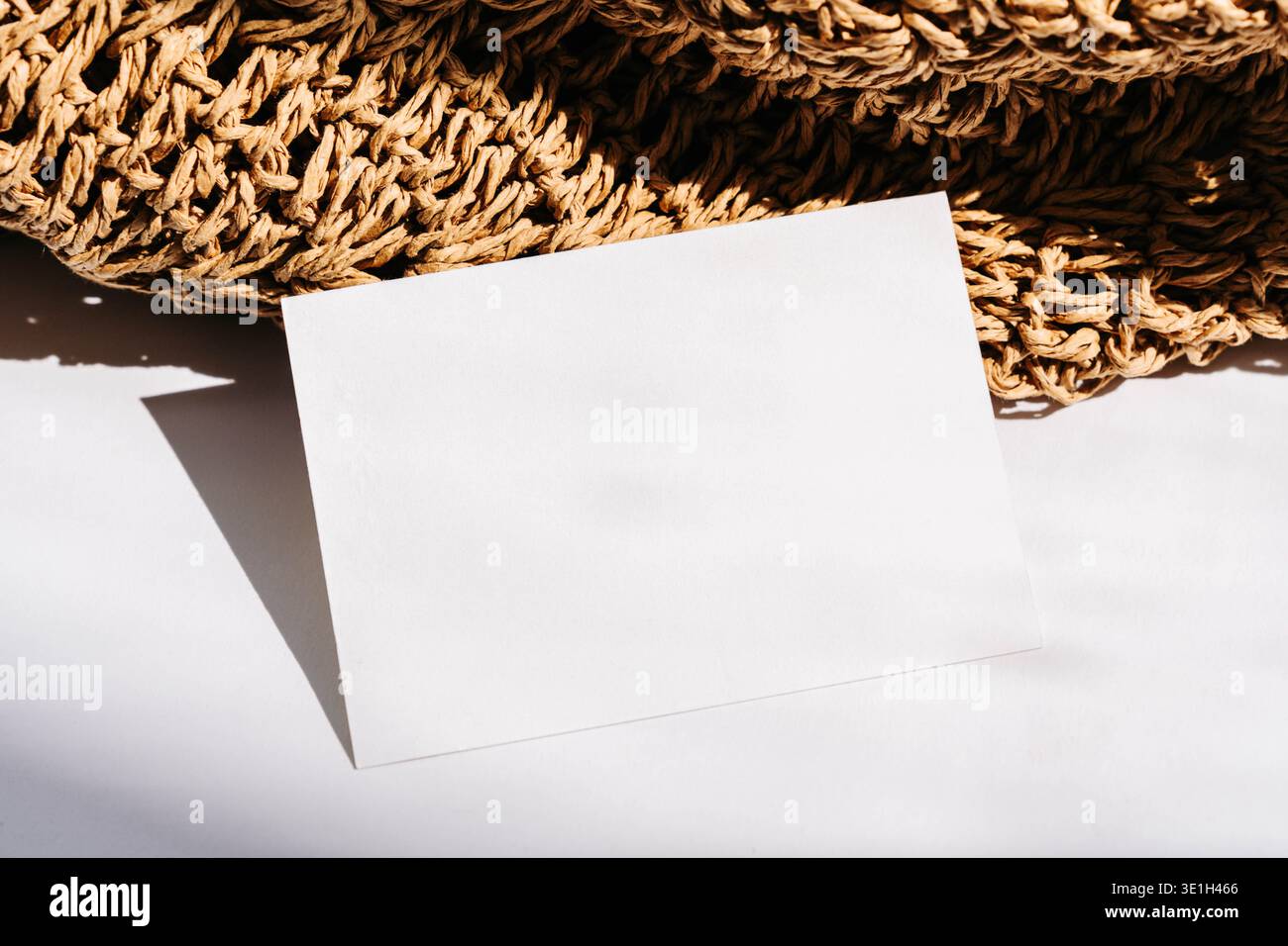 Modello bianco per biglietti da visita su tessuto naturale con luce solare calda e ombre morbide. Modello di branding minimo con spazio di testo per logo o co Foto Stock