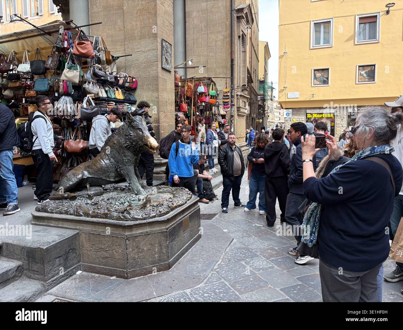 Fontana del Porcellino, il Porcellino. Firenze, Italia. I turisti fotografano la statua di cinghiale in bronzo accanto alle bancarelle del mercato della pelletteria. Foto Stock
