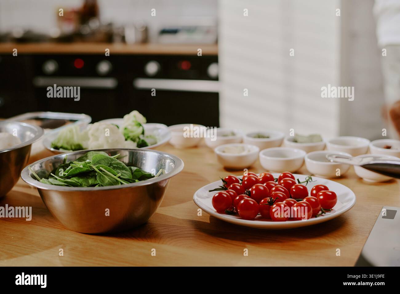 Verdure fresche e ingredienti disposti sul tavolo durante la preparazione della lezione di cucina Foto Stock