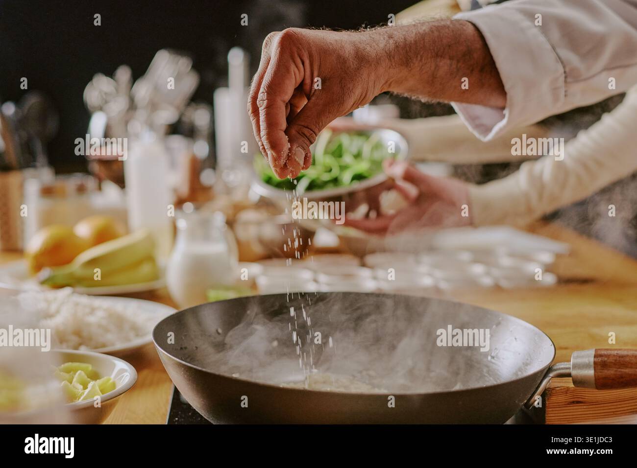 Cibo per condimento dell'uomo caucasico di mezza età durante la lezione di cucina in cucina Foto Stock