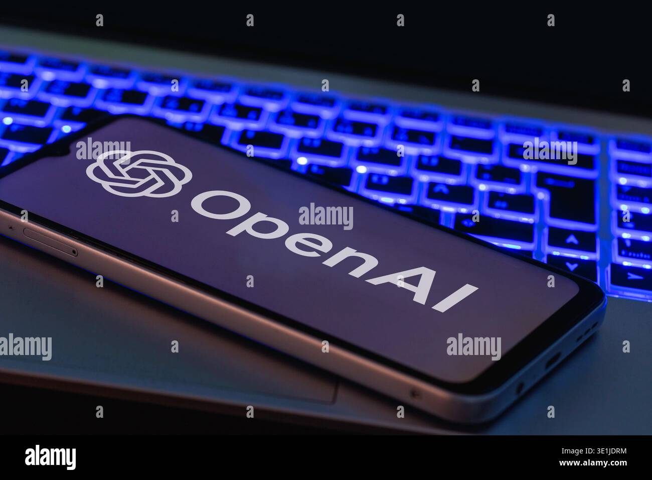 Uno smartphone che visualizza il logo ai APERTO davanti alle tastiere di un notebook Foto Stock