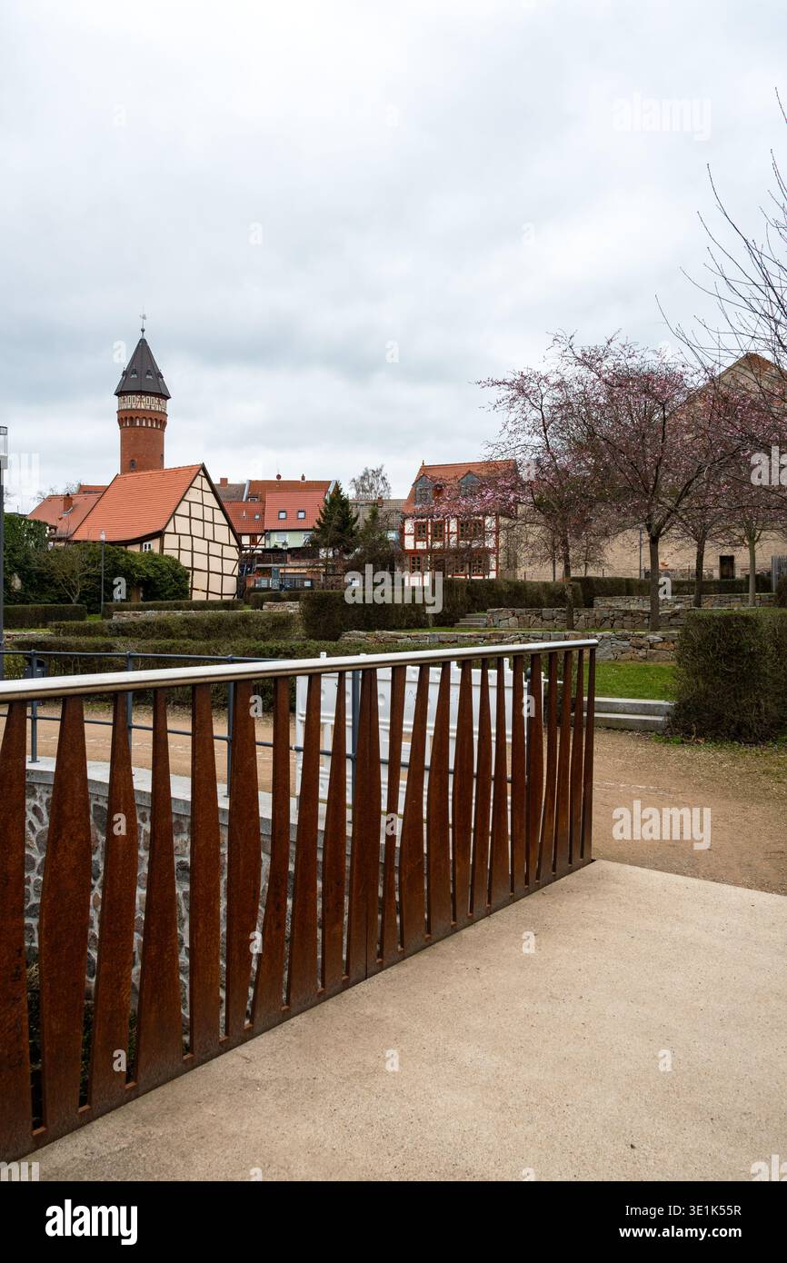 La composizione verticale enfatizza una forte linea guida creata da una moderna ringhiera, che guida lo spettatore attraverso un parco urbano strutturato verso l'histo Foto Stock