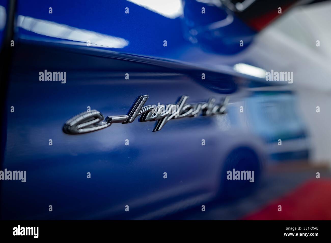 Logo ibrido Porsche Panamera 4 e su carrozzeria blu profonda in interni Foto Stock