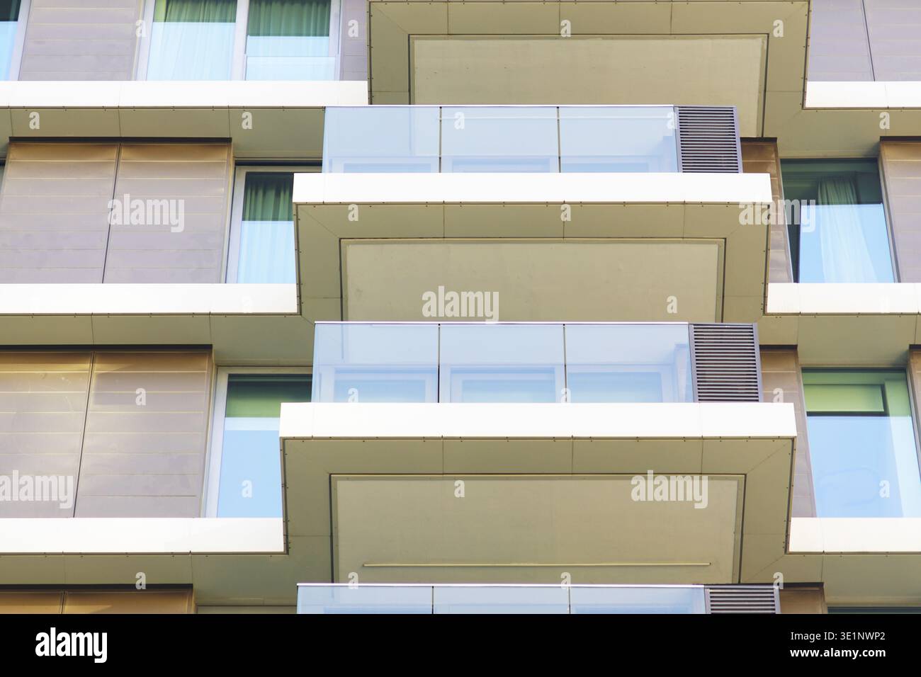Primo piano di balconi ripetuti che formano un ritmo geometrico sulla facciata di un edificio residenziale. Raffigura l'ordine visivo strutturato negli ambienti urbani moderni. Foto Stock