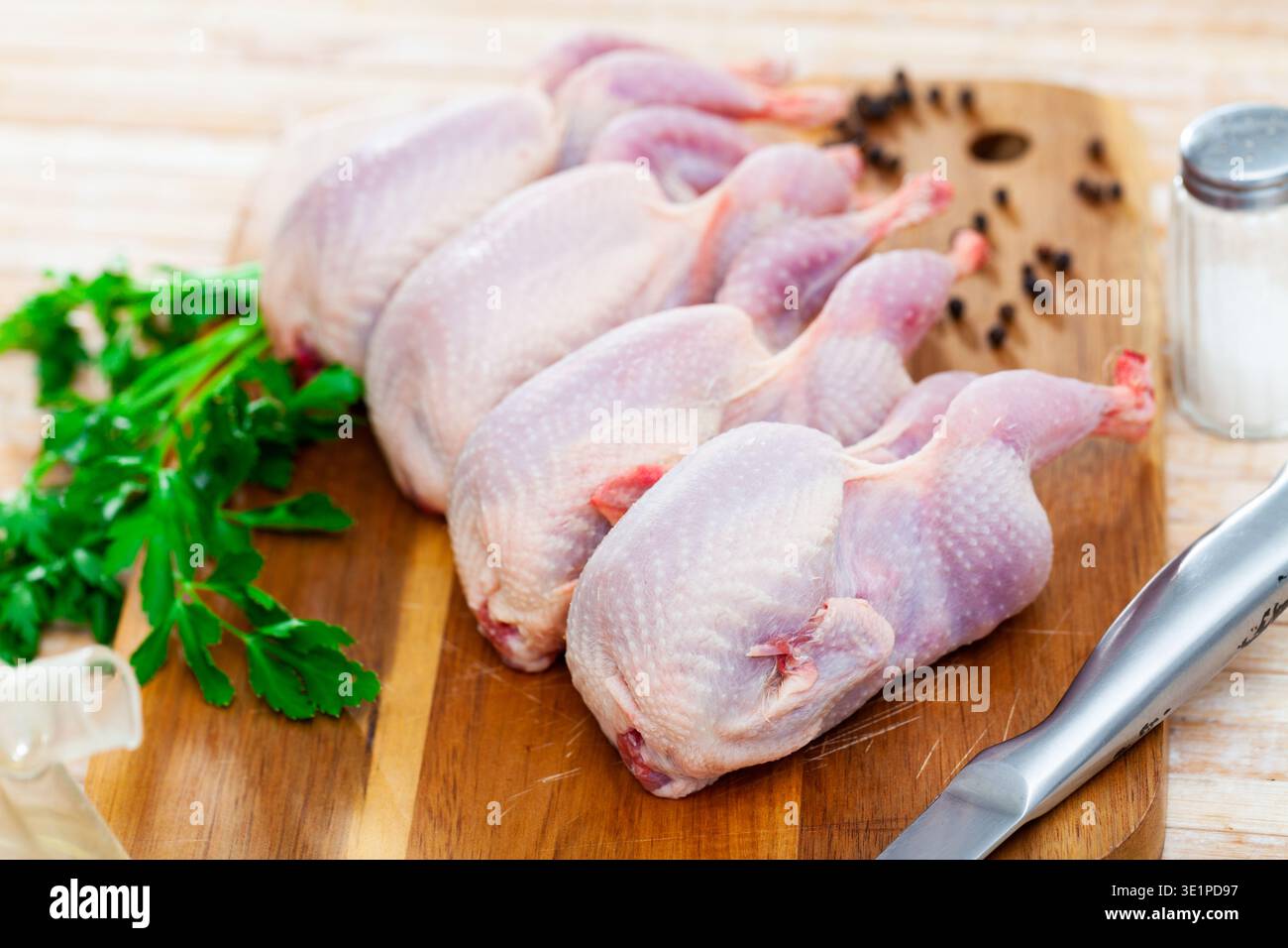 Le carcasse di quaglia si trovano sul tagliere. Piccoli uccelli sono preparati per cucinare Foto Stock