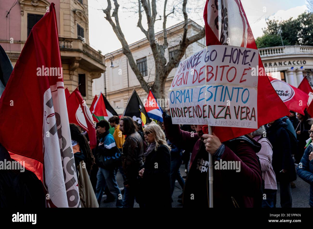 Manifestanti con bandiere cubane, palestinesi e di sinistra. A fuoco, una persona con un cartello: “yankee torna a casa! Ogni debito è ora pagato. Vera indipendenza”. Foto Stock