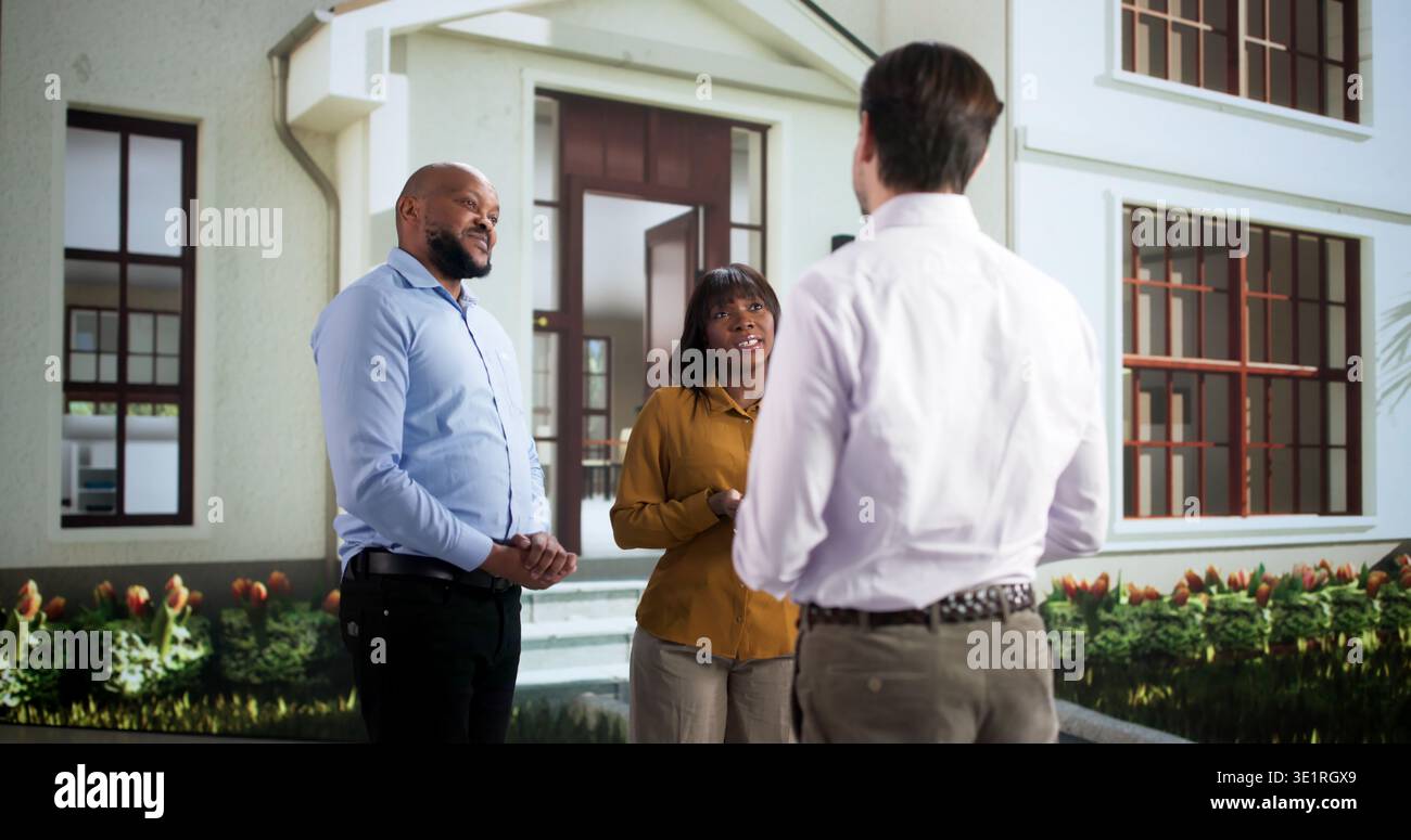 Amici vicini condividono sorrisi mentre scambiano storie nella comunità. Coppia africana dà il benvenuto a New Neighbor Foto Stock
