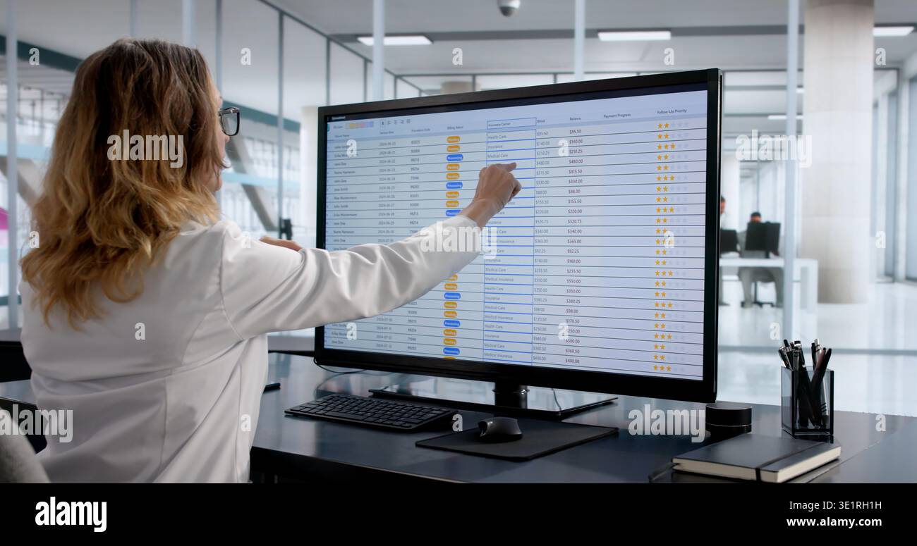 Woman Coding Financial Accounts using computer and Spreadsheet in her Office Foto Stock