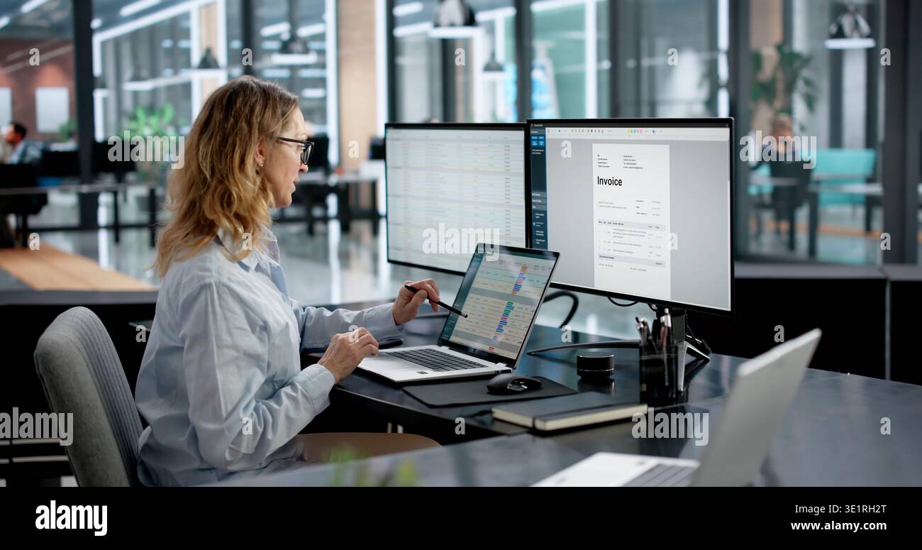 Contabile che crea fatture su monitor in Ufficio medico utilizzando il computer. Donna d'affari che codifica i dati finanziari Foto Stock