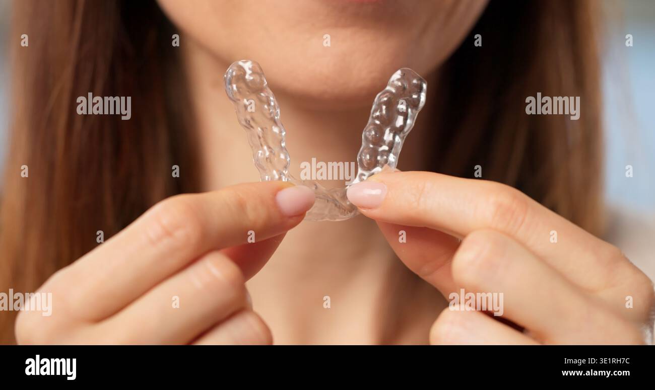 Donna che indossa un allineatore trasparente e una guardia notturna per cure dentistiche Foto Stock