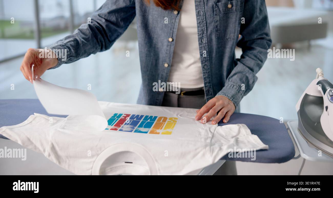 Donna dal design personalizzato pressato a caldo su una t-shirt a casa Foto Stock