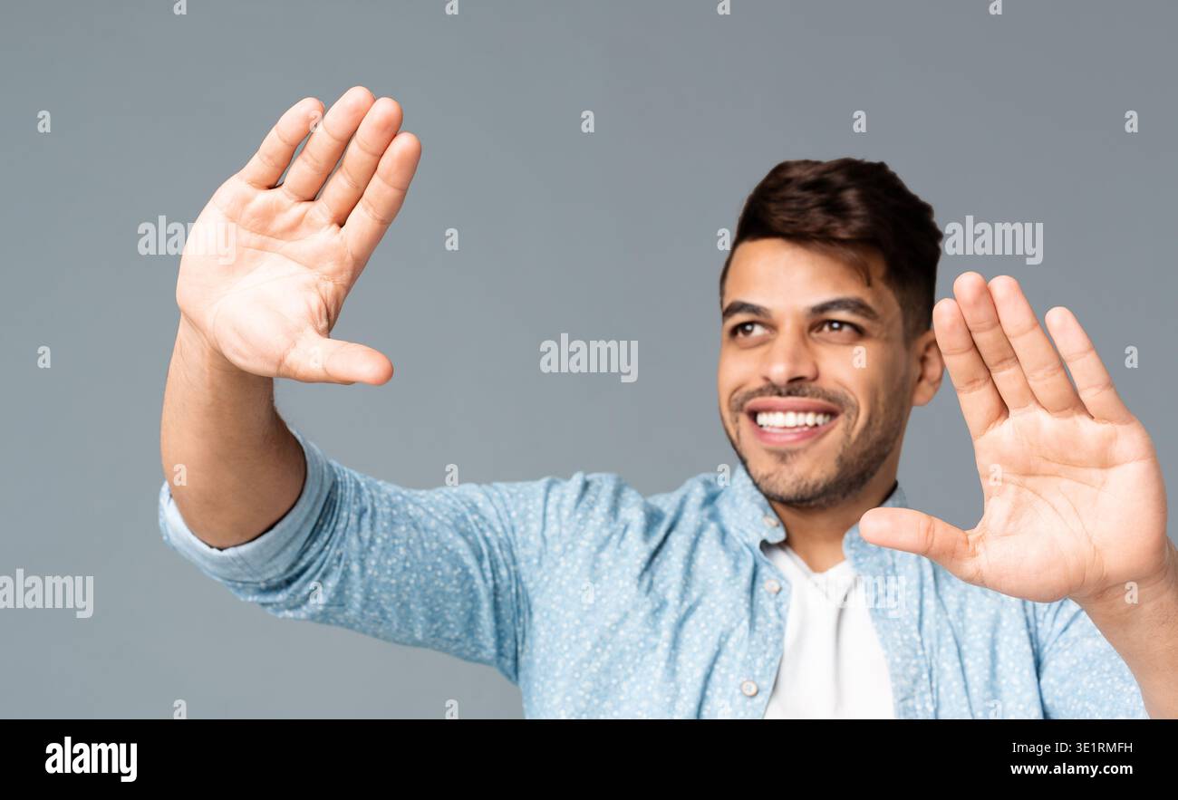 Sorridente Guy rendendo il telaio a mano qualcosa di visualizzazione Foto Stock