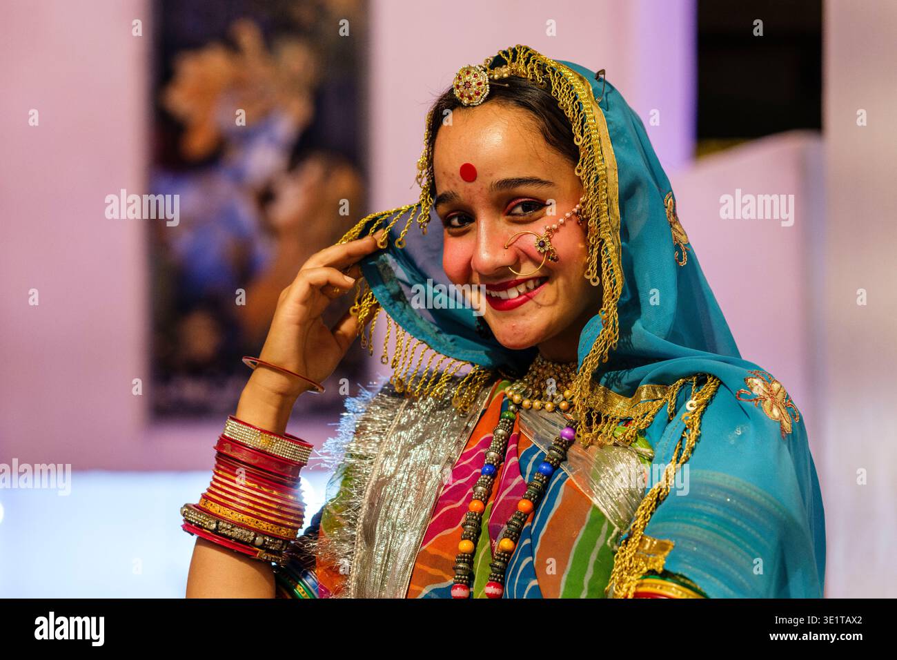Una giovane donna di Udaipur indossa un abito tradizionale, caratterizzato da un dupatta blu con finiture dorate, pesanti bracciali e un bindi decorativo sulla fronte. Foto Stock