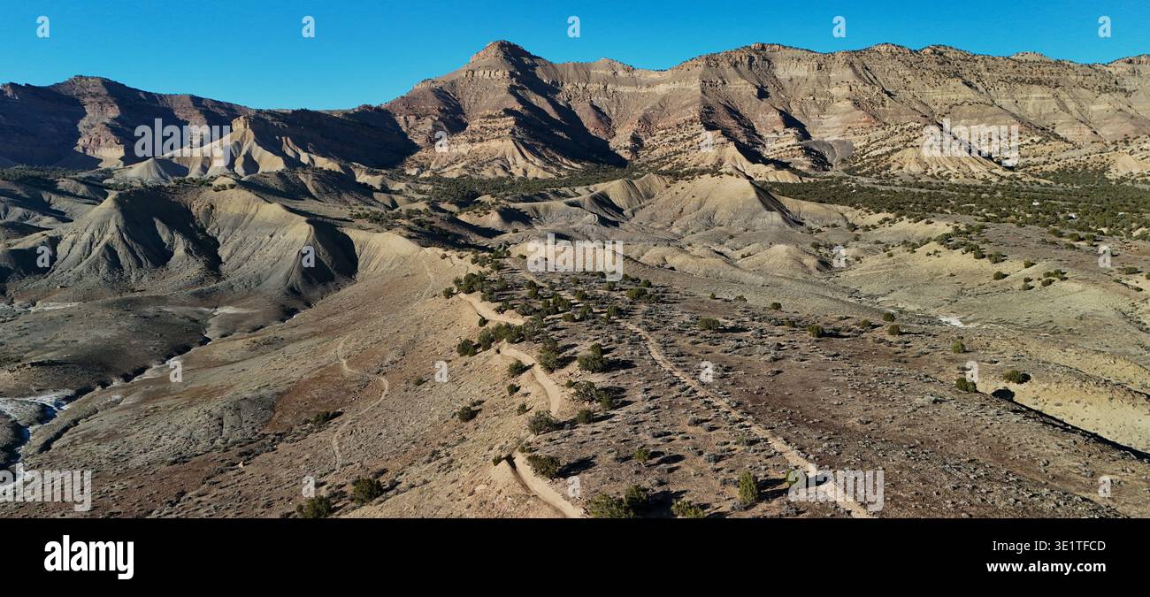 Vista aerea del paesaggio arido con montagne a strati che contrastano con il cielo blu profondo, Fruita, Colorado, Stati Uniti. Foto Stock