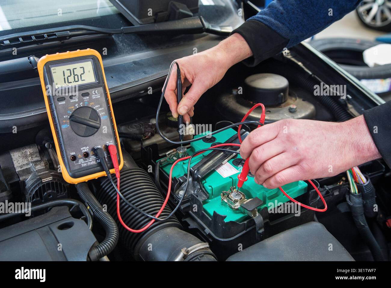 Per controllare la tensione della batteria di un veicolo viene utilizzato un multimetro per il settore automobilistico. Foto Stock