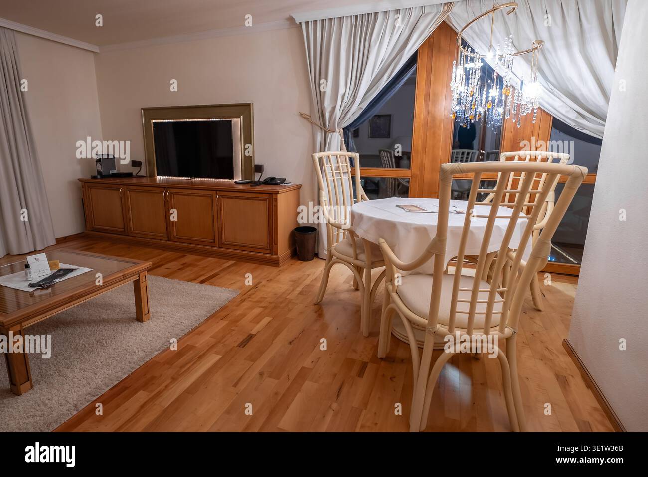 Calda suite d'hotel con area pranzo e soggiorno con accenti di legno alpino Foto Stock