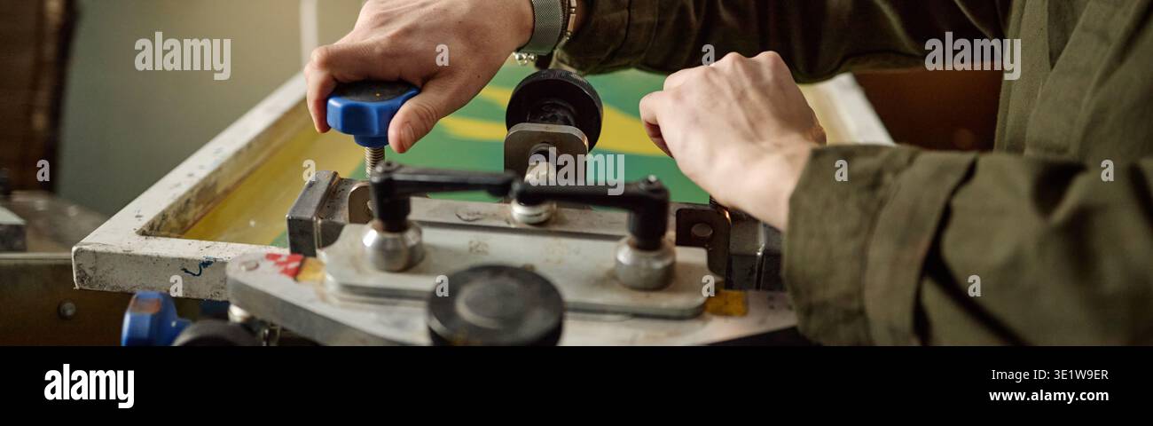 Intestazione della macchina per la stampa dello schermo di Young Adult Man in officina Foto Stock