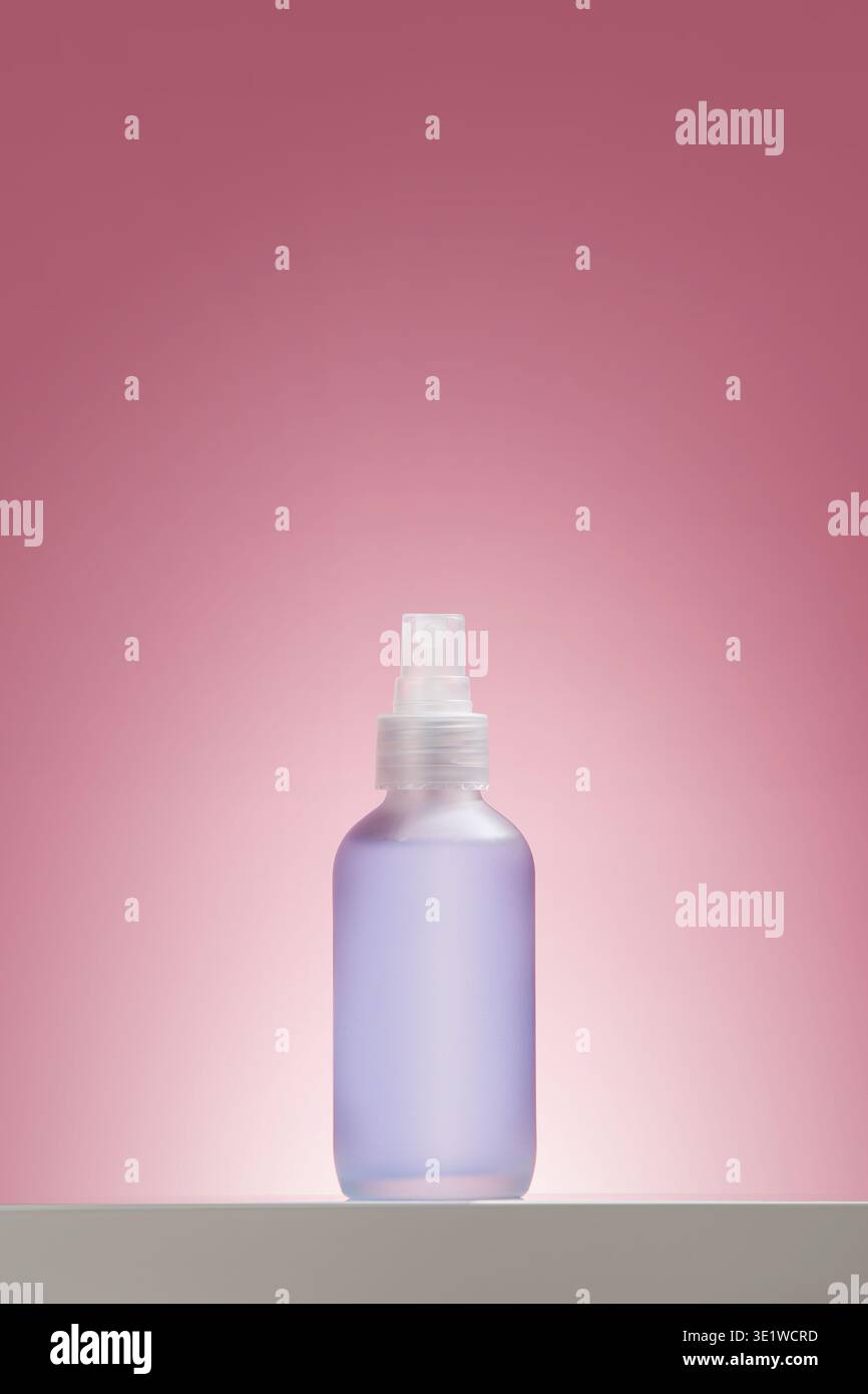 Flacone spray tonico per il viso smerigliato sul rosa Foto Stock