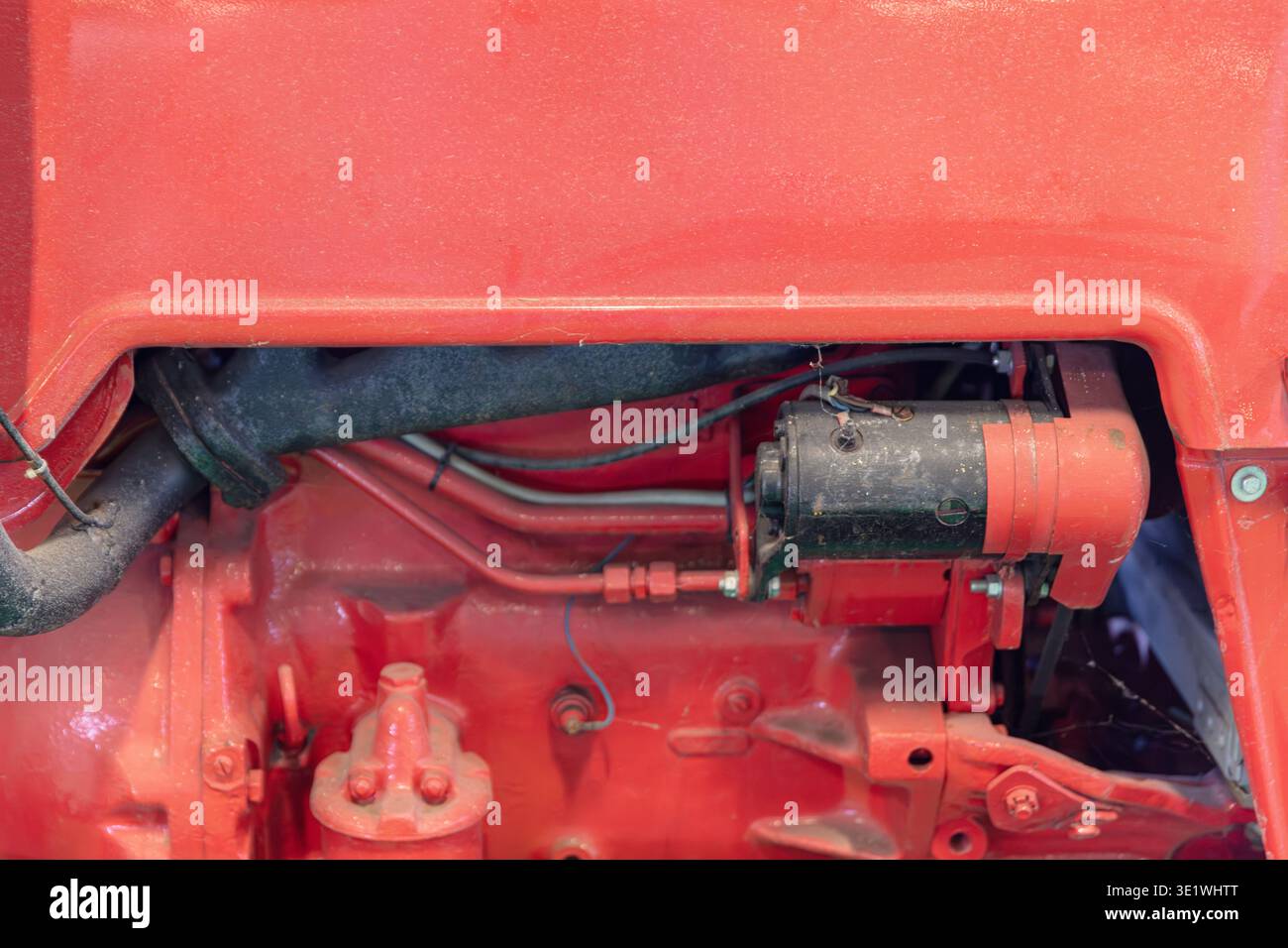 Un'immagine ravvicinata di un motore rosso di un trattore rivela i suoi componenti complessi, tra cui tubi, cablaggi e vari componenti meccanici per il settore agricolo automobilistico Foto Stock