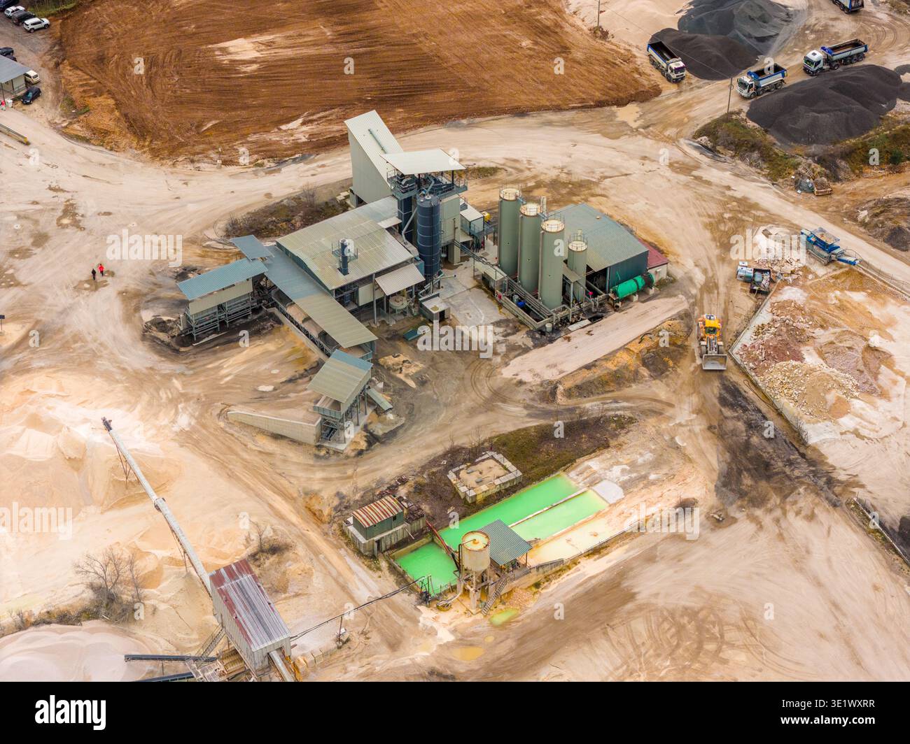 Veduta aerea di un complesso industriale annidato tra i toni della terra, un netto contrasto con le strutture verdi, Magliano de' Marsi, Abruzzo, Italia. Foto Stock