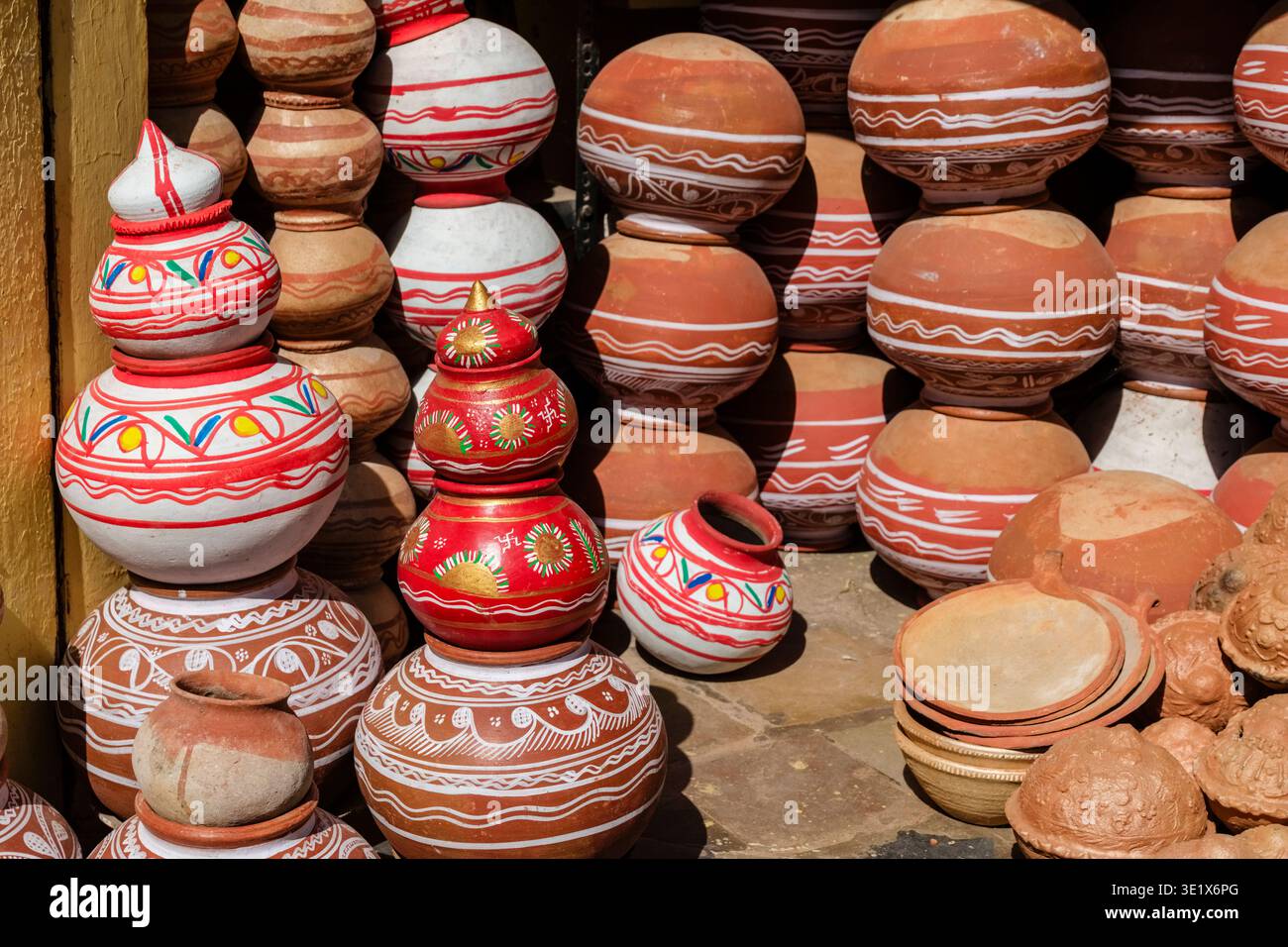 File di vasi d'acqua in terracotta, alcune dipinte con motivi bianchi e rossi, sono esposte in vendita in un mercato tradizionale di Udaipur. Udaipur R Foto Stock
