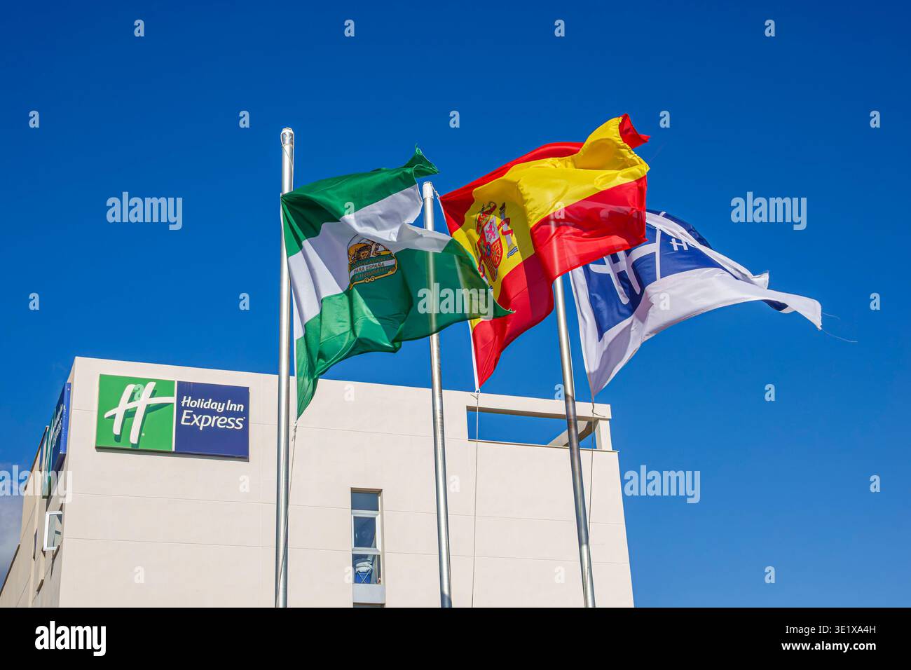 Malaga Spagna,Andalusia Andalusia,hotel Holiday Inn Express,marchio hotel IHG,bandiera regionale Andalusia,bandiera nazionale Spagna,bandiera della Spagna,bandiera della Spagna,bandiera sventolando bandiere su p Foto Stock