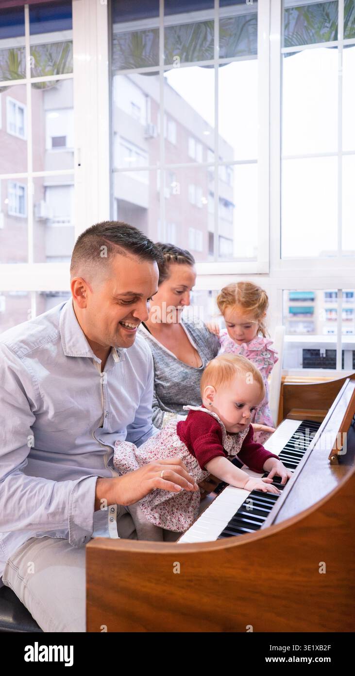 Famiglia felice che ascolta la musica con i propri figli a casa Foto Stock