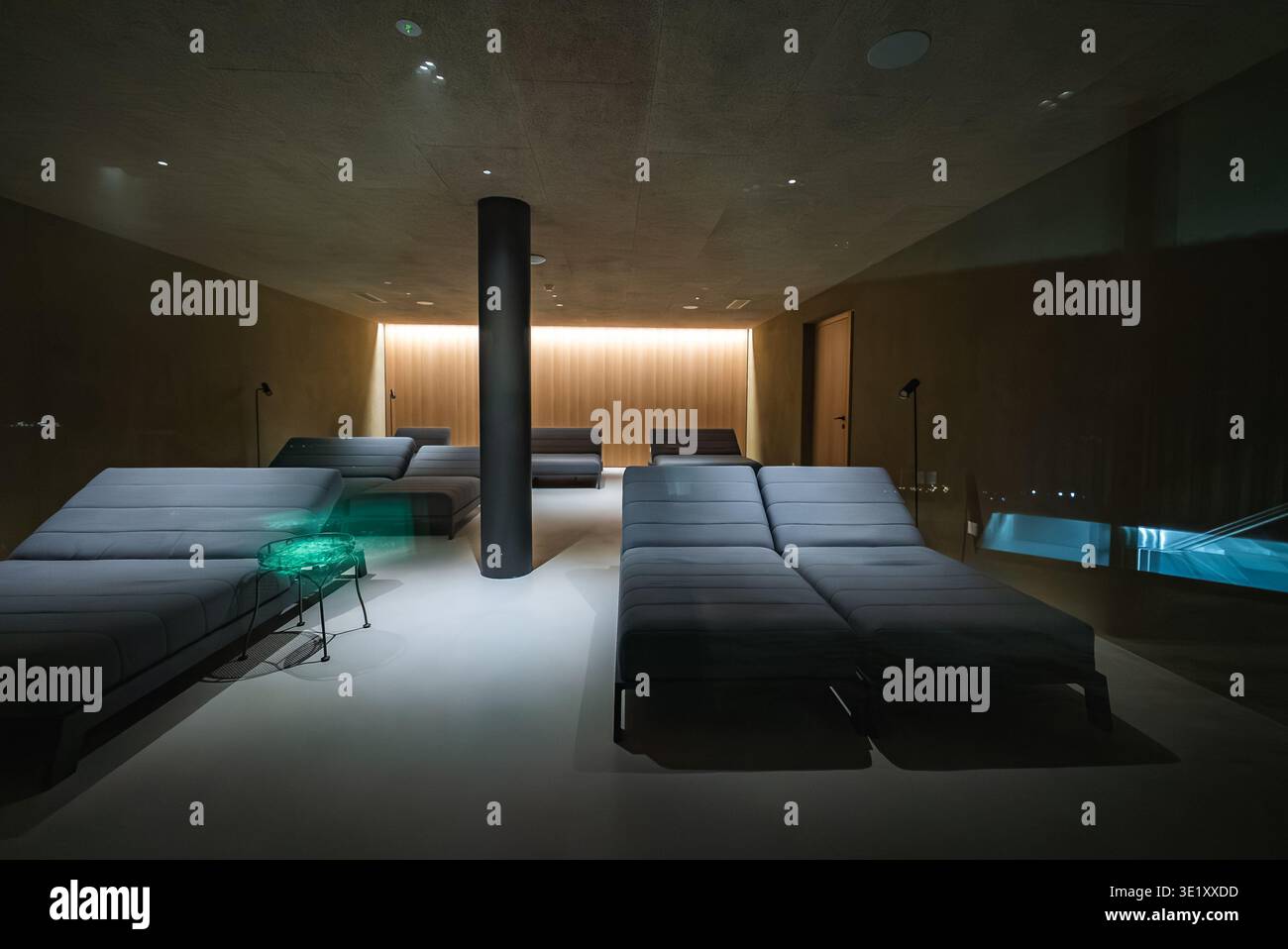 Dim spa lounge con chaise nere, colonna e piscina a tuffo, Dolomiti Foto Stock