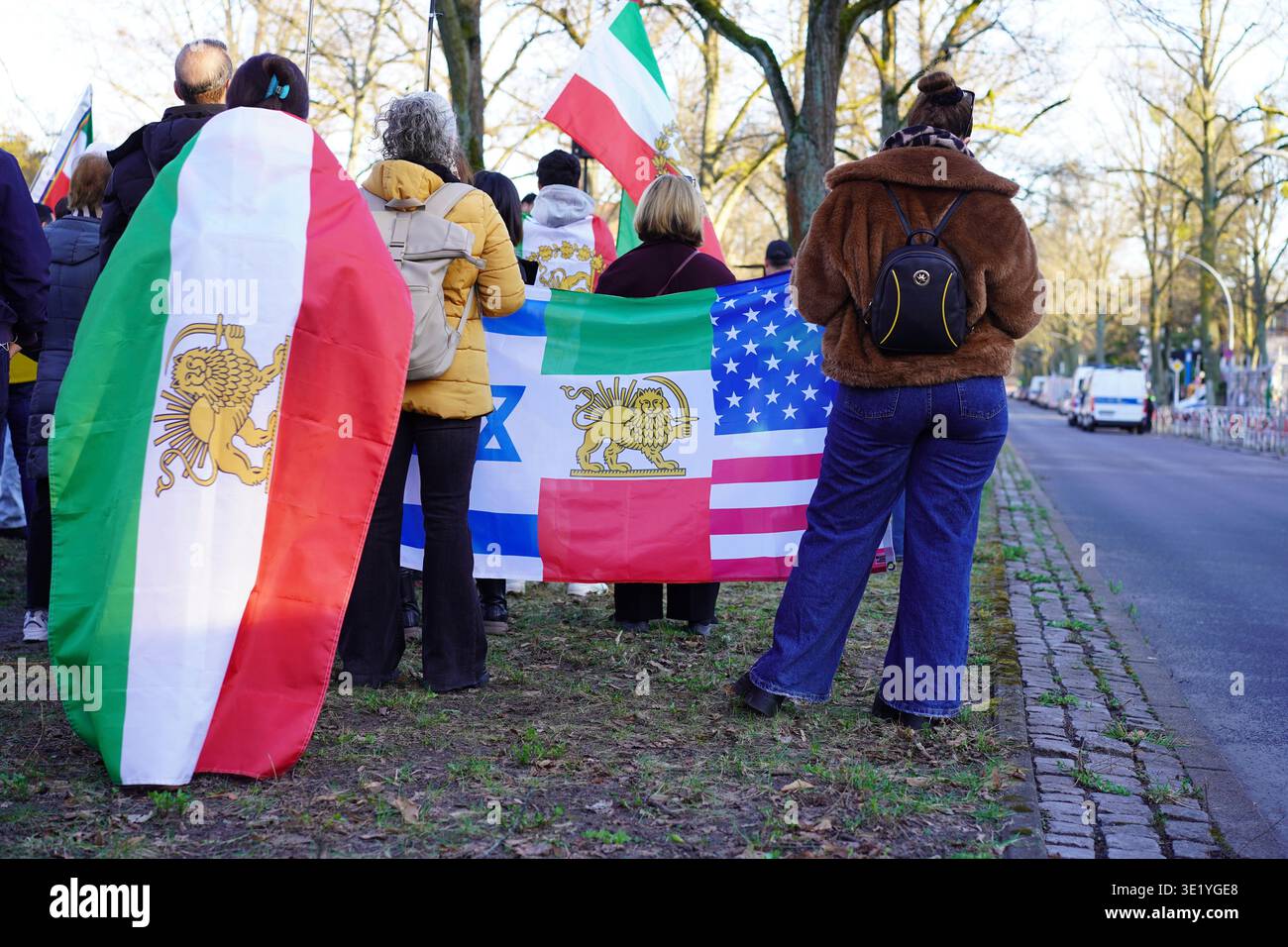 Berlino, Germania - 17 marzo 2026: I manifestanti presso l'ambasciata iraniana hanno una bandiera ibrida per Chaharshanbe Suri, che mostra Leone e Sole, Stati Uniti e Israele. Foto Stock