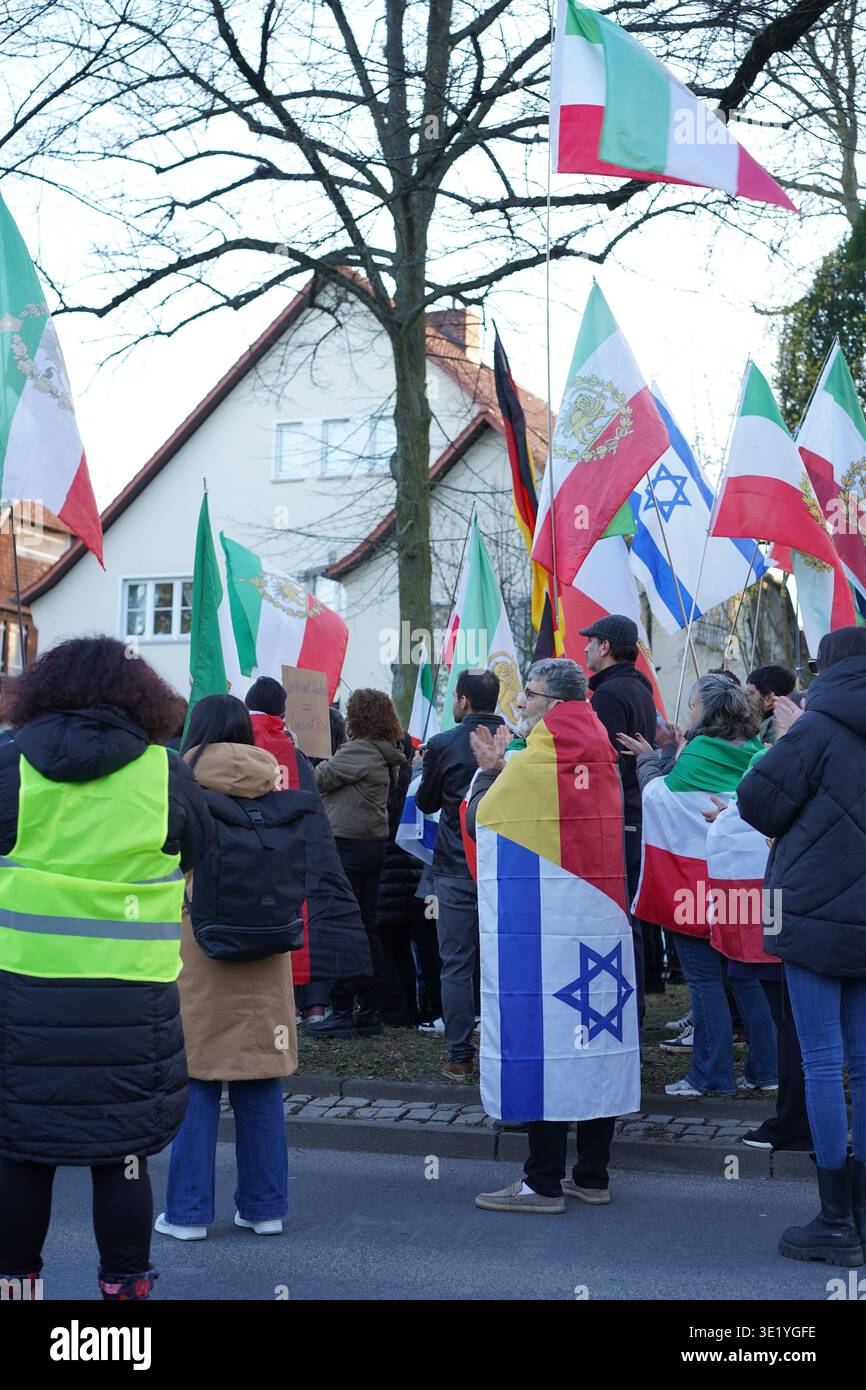 Berlino, Germania - 17 marzo 2026: Manifestante con una bandiera tedesco-israeliana all'ambasciata iraniana per la manifestazione Chaharshanbe Suri con le bandiere del Leone e del Sole. Foto Stock