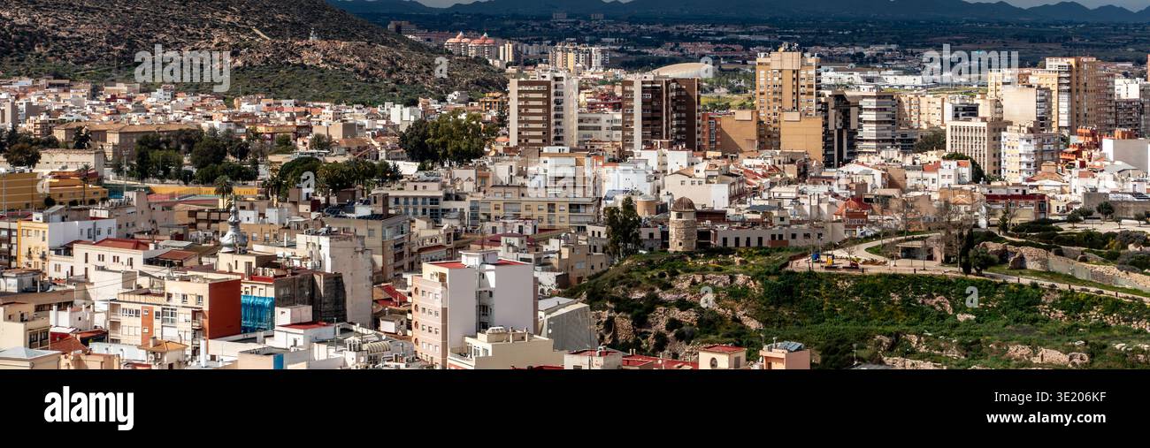 Un'ampia vista panoramica di Cartagena, in Spagna, mostra appartamenti alti, il monumento Torre Ciega e l'espansione urbana verso le montagne. Foto Stock