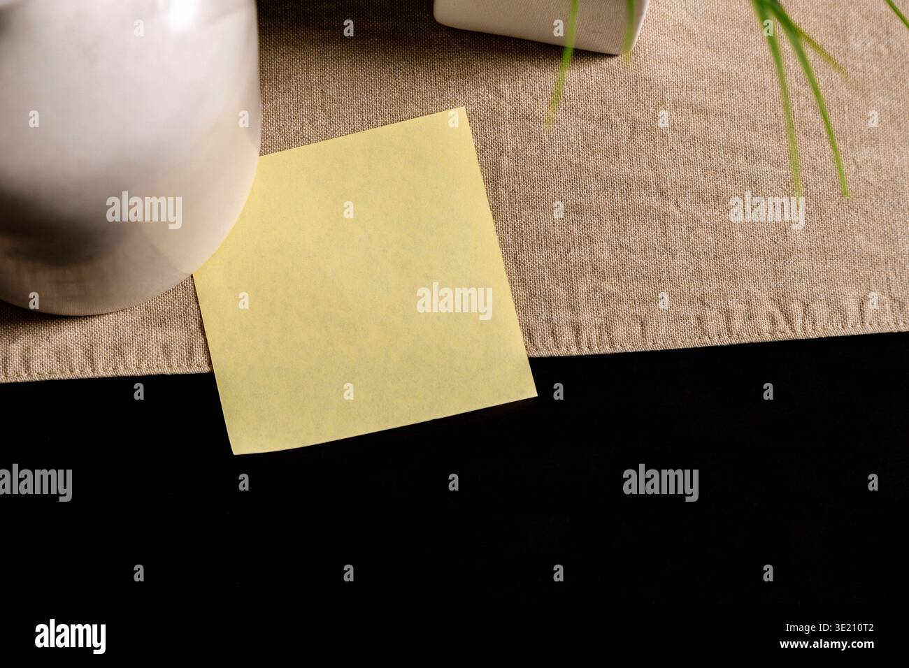 Nota adesiva gialla vuota sulla scrivania con spazio di copia, promemoria minimo e concetto di mockup Foto Stock