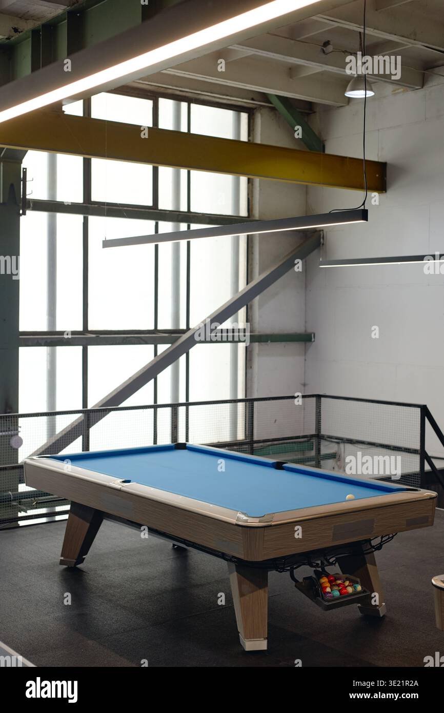 Verticale del moderno tavolo da biliardo in piedi nella sala ricreativa di stile industriale Foto Stock