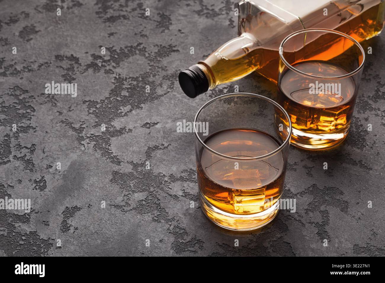 Due bicchieri di whisky e una bottiglia su fondo in marmo Foto Stock