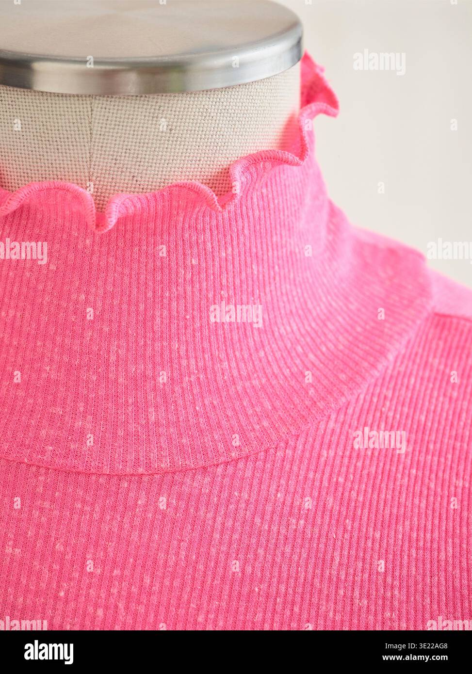 Il manichino presenta un dolcevita a coste rosa brillante con un bordo smerlato. Germania Foto Stock